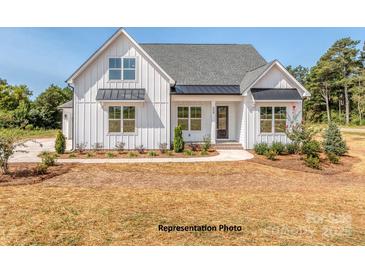 Charming farmhouse with white siding, black metal awnings and roof, and fresh landscaping at 5020 Carolina North Dr, Gastonia, NC 28056
