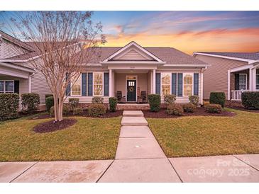 Charming single-story home features manicured lawn, welcoming porch, and stylish shutters at sunset at 11135 Bailey Park Nature Dr, Cornelius, NC 28031