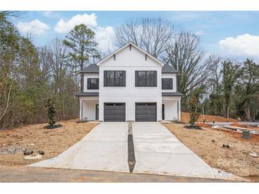 Modern, white two-story home featuring a double garage and a long, concrete driveway at 2811 New Pineola Rd, Charlotte, NC 28208