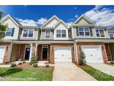 Charming townhome featuring a brick facade, white garage door and a well maintained lawn at 4242 Black Ct # 233, Harrisburg, NC 28075