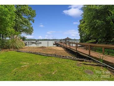Lakefront home with a wooden dock, gazebo and boat in the background, providing a picturesque waterfront lifestyle at 5580 Crepe Myrtle Rd, York, SC 29745