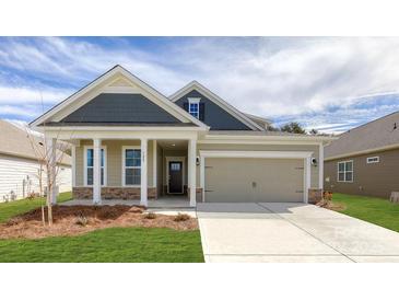 Charming single-Gathering home featuring a welcoming front porch, stone accents, and a two-car garage at 121 Noah Ln, Troutman, NC 28166
