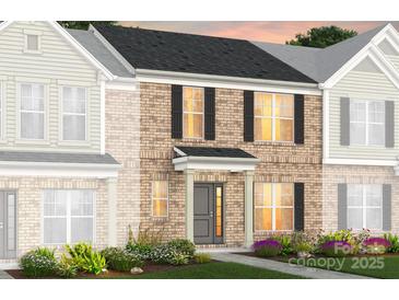 Charming two-story townhome showcasing a brick facade, black shutters, and inviting front door at 2232 Cobble Ct # 153, Monroe, NC 28110