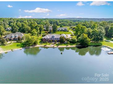 Expansive lakefront estate with lush greenery providing privacy and scenic views, perfect for luxurious living at 6823 Manatee Dr, Concord, NC 28025