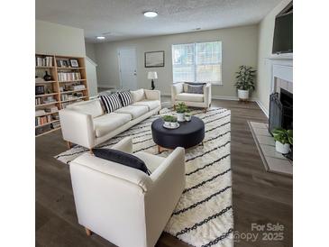 Bright living room featuring modern furniture, fireplace, and a stylish area rug at 2303 Hope Valley Ln, Charlotte, NC 28213