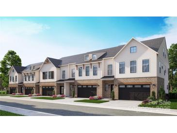 Charming townhomes featuring brick accents, black garage doors, and manicured landscaping at 3104 Endhaven Terraces Ln # 8, Charlotte, NC 28277