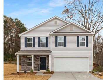 Charming two-story home featuring light gray siding, a two-car garage, and a welcoming front porch with stone accents at 5156 Fireweed Ct, Dallas, NC 28034