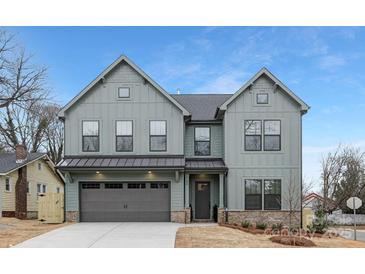 Beautiful new construction home featuring a two-car garage, craftsman details, and a sodded front yard at 600 Campus St, Charlotte, NC 28216