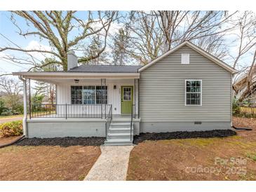 Charming single-story home featuring a cozy front porch, fresh paint, and a well-manicured lawn at 723 Wood St, Statesville, NC 28677