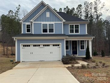 Charming two-story home with light blue siding and a white two-car garage at 107 Spring View Ln, Statesville, NC 28677