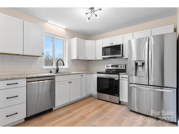 Modern kitchen featuring stainless steel appliances, white cabinetry, and light countertops at 4065 Lost Creek Ct, Hickory, NC 28602