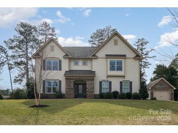 Beautiful two-story home with stone accents, manicured lawn, and a separate garage; perfect for a Gathering at 4131 Nottaway Place Dr, Matthews, NC 28105