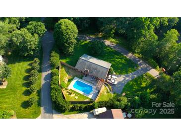Aerial view of a home with a backyard pool, a fenced-in yard, and driveway parking at 6108 Gold Creek Estate Dr, Hickory, NC 28601