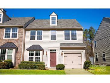 Charming two-story townhome with beige siding, attached garage, and well-maintained front lawn at 9760 Springholm Dr, Charlotte, NC 28278
