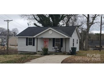 Cozy single-story home with vinyl siding, dark shutters, covered porch, and a concrete driveway at 1021 E Airline Ave, Gastonia, NC 28054