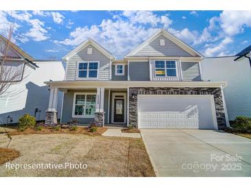 Charming two-story home with gray siding, stone accents, covered front porch, and a two-car garage at 108 Ellsworth Rd # 40, Mooresville, NC 28115