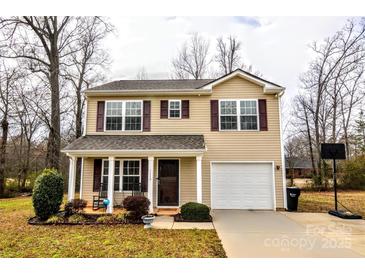 Charming two-story home featuring a cozy front porch, attached garage, and well-maintained landscaping at 1113 Eastwood Dr, Wingate, NC 28174