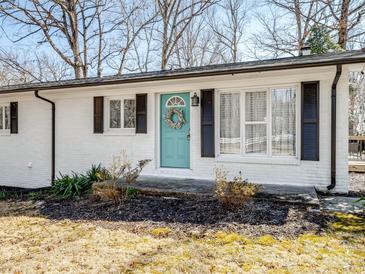 Charming white home with inviting front door and well-manicured landscaping at 13470 Austin Rd, Locust, NC 28097