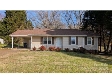 Charming single-story home featuring a carport and quaint front porch with lovely landscaping at 219 W Edison Dr, Statesville, NC 28625