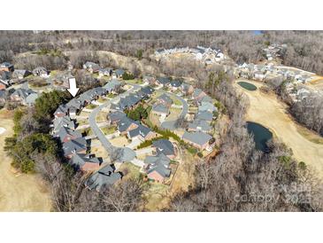 An aerial view shows a neighborhood with brick homes, a golf course, ponds, and mature trees in a suburban setting at 4008 Saint Andrews Ct, Cramerton, NC 28032