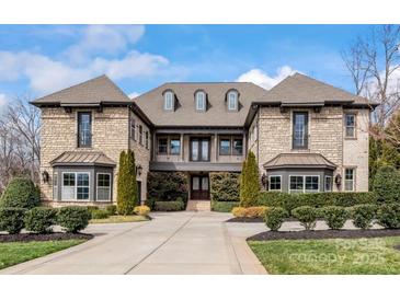 Elegant stone home featuring manicured landscaping and symmetrical design elements, with a welcoming front entrance and charming architectural details at 1238 Ladera Dr, Waxhaw, NC 28173
