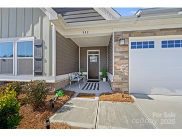 Charming front porch with stone accents, bench, and welcoming decor at 1332 Augustus Beamon Dr, Indian Trail, NC 28079
