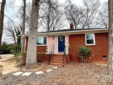 Charming brick home featuring a welcoming blue door and a well-maintained front yard at 1936 Russell Ave, Charlotte, NC 28216