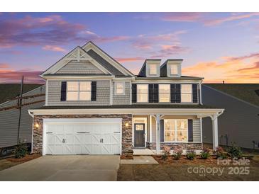Charming two-story home with stone accents, shingle siding, white garage door, and manicured landscaping at 8720 Acadia Pkwy # 597, Sherrills Ford, NC 28673