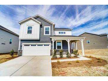Charming two-story home featuring a two-car garage and covered front porch at 1471 Honey Trl, Monroe, NC 28112