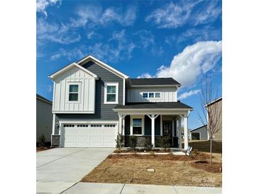 Beautiful two-story home with a two car garage, stone accents, and a charming covered front porch at 1471 Honey Trl, Monroe, NC 28112