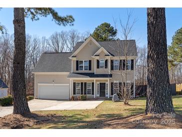 Charming two-story home with an attached garage, well-maintained lawn and black window shutters at 152 Painted Bunting Dr, Troutman, NC 28166