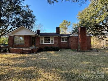 Charming single-story brick home featuring a classic design and inviting front porch at 3694 Nc Highway 109 S Hwy, Mount Gilead, NC 27306