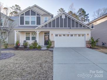 Charming two-story home with a white garage door, covered porch and well-maintained landscaping at 5028 Colline Ct, Charlotte, NC 28216