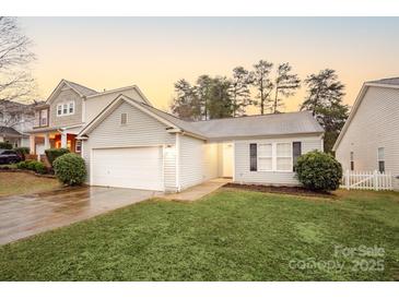 Charming single-story home featuring a well-maintained lawn, attached garage, and neutral siding at 6025 Raisin Tree Ln, Charlotte, NC 28215