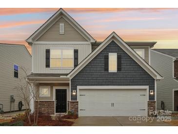 Charming two-story home featuring a two-car garage, stone accents, and warm exterior lighting at 6509 Gopher Rd, Lancaster, SC 29720