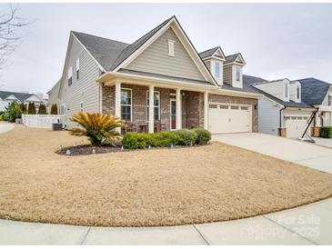 Charming single-Gathering home with manicured lawn, brick accents, and a two-car garage at 105 Blossom Ridge Dr, Mooresville, NC 28117