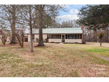 Charming single-story home featuring a screened porch, metal roof, and mature trees on a spacious lot at 2845 Wood Gate Rd, Lincolnton, NC 28092