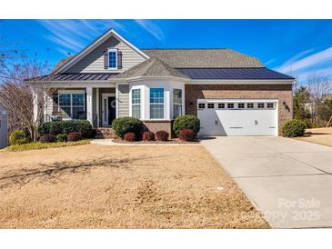 Charming single-story home with a well-manicured lawn, a brick and gray siding exterior and an attached two-car garage at 469 Hawks Creek Pkwy, Fort Mill, SC 29708