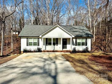 Charming single-story home with white siding, a gray roof, a spacious driveway and well-maintained landscaping at 514 Meadowrock Dr, Albemarle, NC 28001