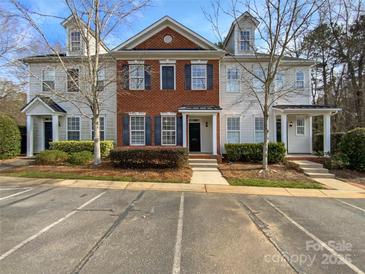 Charming brick townhouse with blue shutters, set in a desirable neighborhood with well-maintained landscaping and ample parking at 111 Charterhouse Ln, Fort Mill, SC 29715
