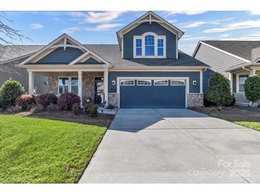 Charming two-story home with a manicured lawn and a two-car garage on a sunny day at 1284 Independence St, Tega Cay, SC 29708