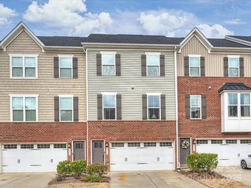 Beautiful townhome features a brick facade, attached garages, and manicured landscaping at 2536 Grantham Place Dr, Fort Mill, SC 29715