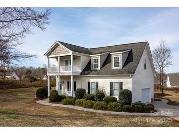 Charming two-story home with a double front porch and landscaped yard at 662 Georgie St, Troutman, NC 28166
