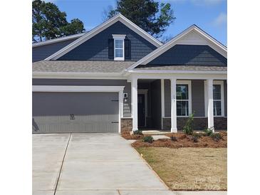 Charming single-Gathering home with a gray garage, gray siding, and a inviting front porch with brick accents at 113 Noah Ln, Troutman, NC 28166