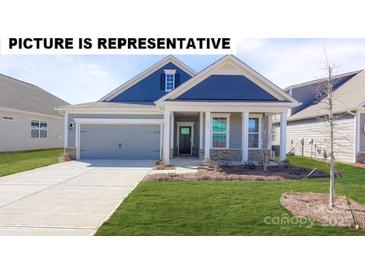 Charming home featuring a well-maintained lawn, a grey two-car garage, and a welcoming front porch at 117 Noah Ln, Troutman, NC 28166