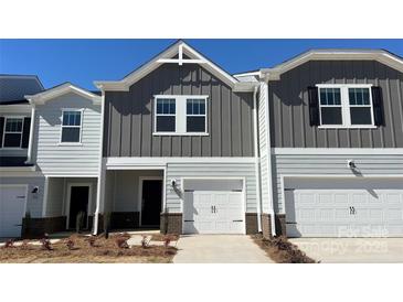 Charming townhome featuring a one-car garage, modern gray siding, and a well-manicured front yard at 1733 Braemar Village Dr, Monroe, NC 28110