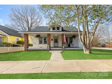 Charming single-story home featuring a welcoming front porch, complemented by a well-manicured lawn and inviting curb appeal at 239 Euclid Ave, Statesville, NC 28677