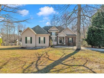 Charming two-story home with a brick and vinyl exterior, lush lawn, and an inviting entrance at 304 Keller St, China Grove, NC 28023
