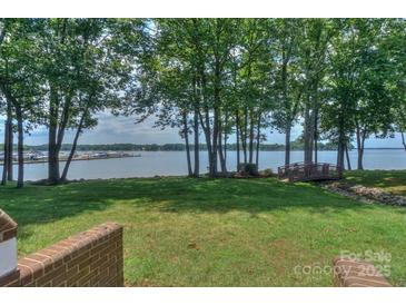 Expansive backyard with mature trees, a foot bridge, and stunning lake views at 405 Northwest Dr, Davidson, NC 28036
