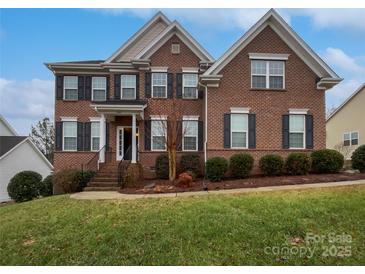 Beautiful two-story brick home featuring black shutters, landscaped yard, and covered front porch at 509 Riviera Pl, Rock Hill, SC 29730